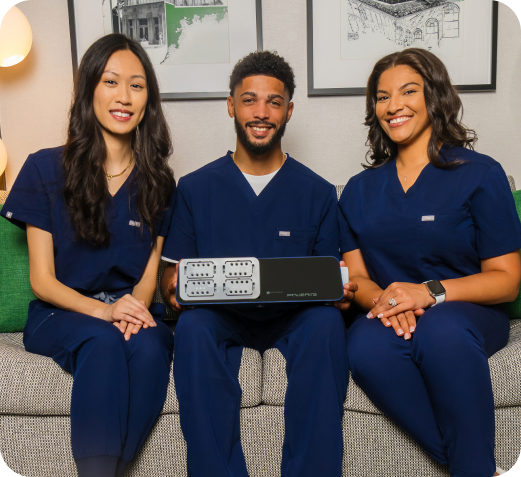 Three clinicians holding the PnueAira device